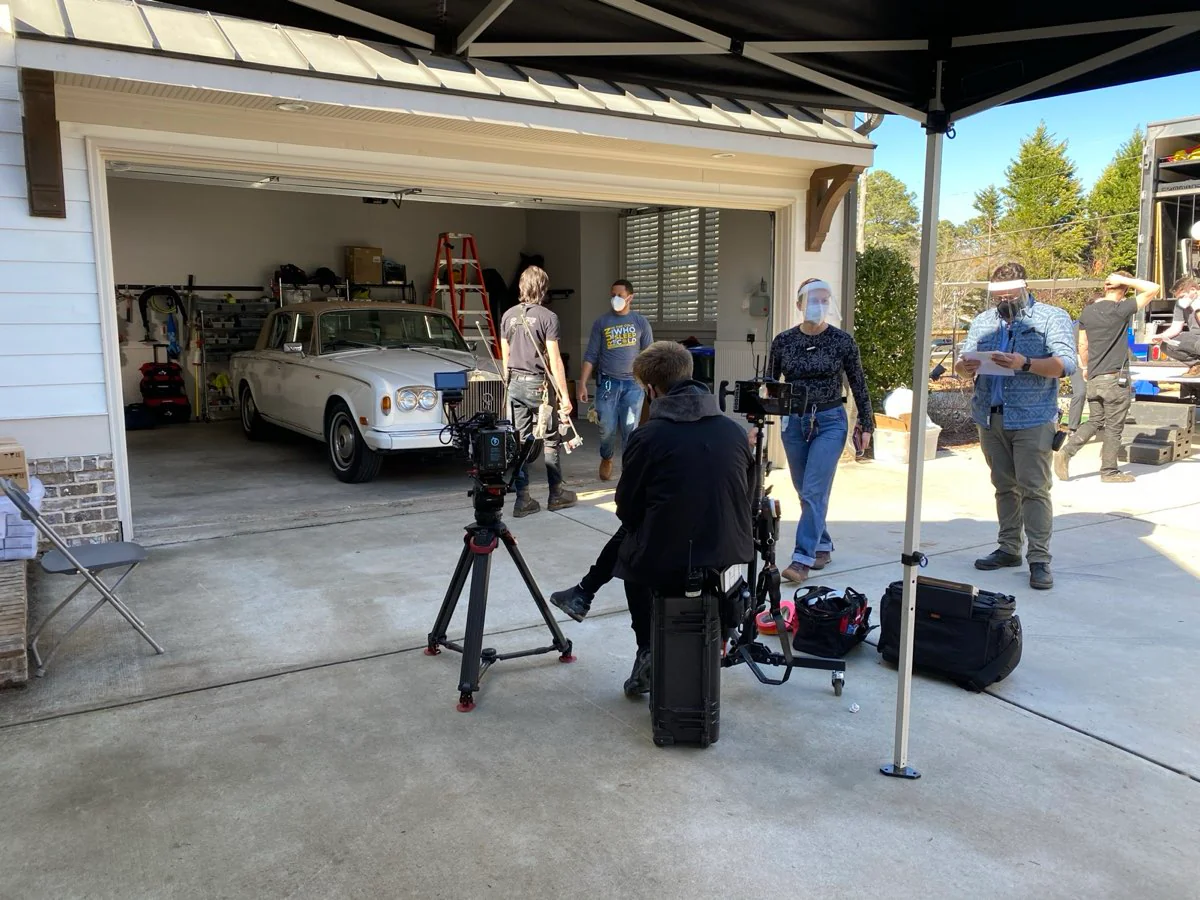 Crew filming a vintage Rolls-Royce in a driveway
